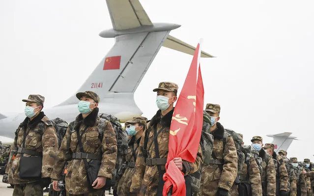 In this photo released by China's Xinhua News Agency, Chinese military medical staff members stand in formation after arriving at Wuhan Tianhe International Airport in Wuhan in central China's Hubei Province, Sunday, February 2, 2020. The Philippines on Sunday reported the first death from a new virus outside of China, where authorities delayed the opening of schools in the worst-hit province and tightened quarantine measures in a city that allow only one family member to venture out to buy supplies. (Photo by Cheng Min/Xinhua via AP Photo)