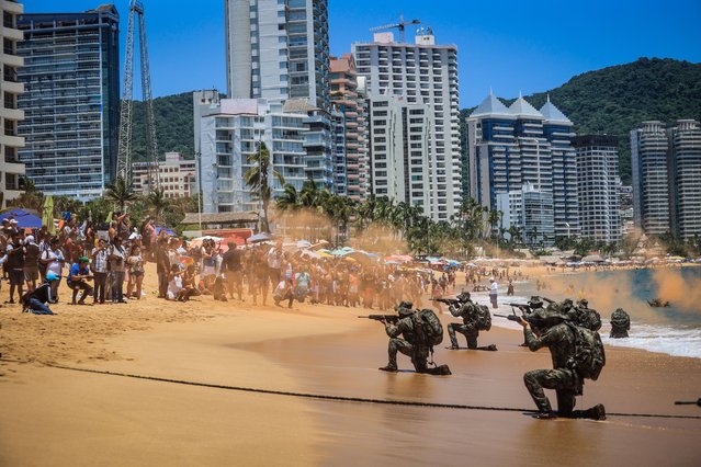 Members of the Mexican Navy participate in an amphibious rescue practice as tourists watch on the “Icacos” beach, in the resort of Acapulco, Guerrero state, Mexico, 23 July 2023. Agents of the Mexican Navy carried out a security and surveillance demonstration to protect the integrity of national and international vacationers who visit the port of Acapulco. (Photo by David Guzman/ EPA)