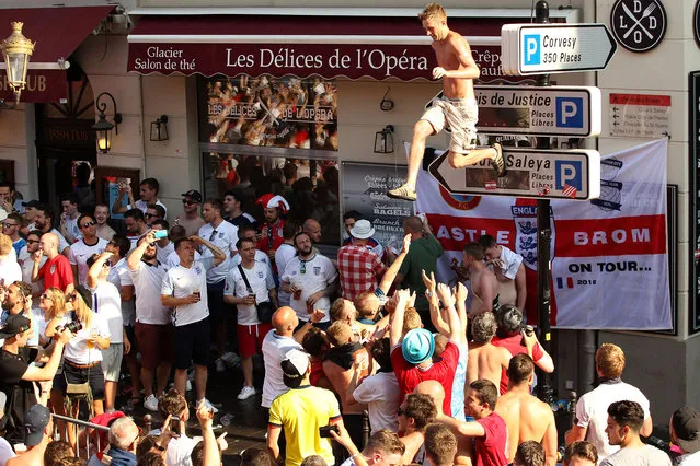 A man jumps from a road sign as England's supporters gather ahead of the Euro 2016 football tournament match England vs Iceland on June 27, 2016 in Nice, southeastern France. (Photo by Jean Christophe Magnenet/AFP Photo)