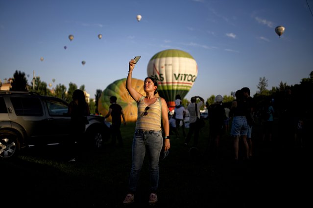 Fifty hot air balloons from various countries, including England, France, Brazil, Monaco, Italy, Switzerland, Tunisia, and Morocco, are prepared to float in the sky during the first day of The European Balloon Festival, the largest hot air balloon event in southern Europe, held in Igualada, Barcelona, Spain on July 11, 2024. The festival is featuring the world premiere of the Space Aerostatic Capsule, a closed and pressurized cabin designed to fly at 20,000 meters altitude, developed by the aerospace company Zero 2 Infinity and adapted by the local company Ultramagic. This capsule is the result of an experimental project inspired by the music producer Burak Yeter, who plans to perform DJ sets at high altitudes. (Photo by Lorena Sopena Lopez/Anadolu via Getty Images)