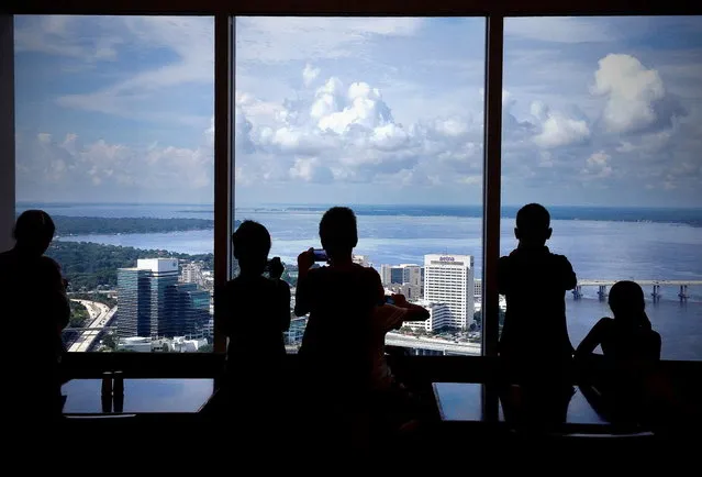 Photographers from the Museum of Contemporary Art Jacksonville photography camp take pictures from the 42nd floor of the Bank of America tower on Thursday, July 10, 2014, in Jacksonville, Fla. The young photographers are spending about half their time shooting pictures and the other half on the computer learning Photoshop techniques. Mario Peralta, their instructor, says the campers have been working on a variety of assignments including; collages, silhouettes, textures and multiple exposures. (Photo by Bruce Lipsky/AP Photo/Florida Times-Union)