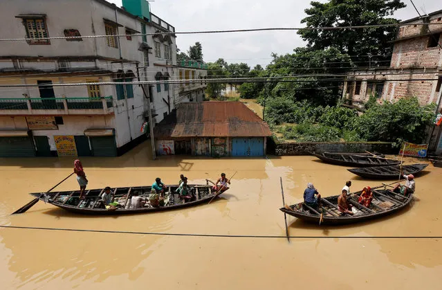 People use boats as they try to move to safer places along a flooded street in West Midnapore district, in the eastern state of West Bengal, India, July 27, 2017. (Photo by Rupak De Chowdhuri/Reuters)