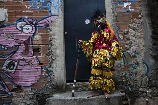 A boy dressed as a clown waits for the start of the meeting of the Kings' Revelry groups in the Santa Marta favela, as part of cultural events celebrating Black Awareness month, in Rio de Janeiro, Brazil, Saturday, November 13, 2021. (Photo by Bruna Prado/AP Photo)