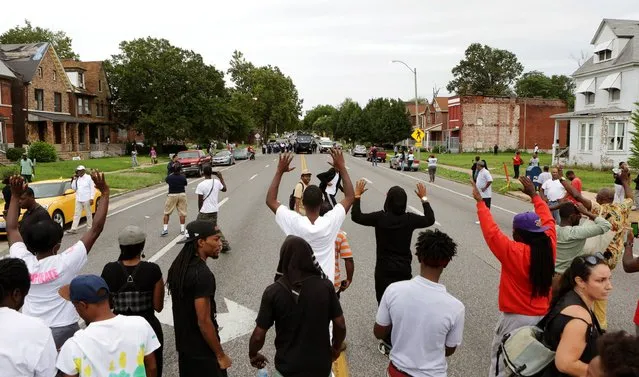Protestors hold their hands up as police approach them on Page Ave. after a shooting incident in St. Louis, Missouri August 19, 2015. (Photo by Lawrence Bryant/Reuters)
