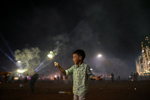 A boy plays with firecrackers during Diwali, the Hindu festival of lights, in Mumbai, India, on October 31, 2024. (Photo by Indranil Aditya/NurPhoto/Rex Features/Shutterstock)