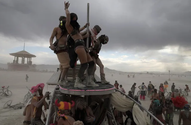 Burning Man participants dance on and around “The Penetrator” art car near the effigy of “The Man” at the Burning Man arts and music festival in the Black Rock Desert of Nevada, U.S. August 30, 2017. (Photo by Jim Urquhart/Reuters)