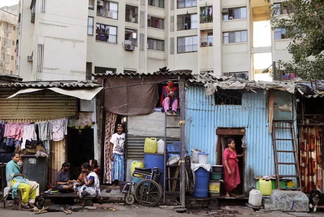Impoverished Indians rest by their shanties at Dharavi, one of Asia's largest slums, during lockdown to prevent the spread of the coronavirus in Mumbai, India, Friday, April 3, 2020. A nationwide lockdown announced last week by Prime Minister Narendra Modi led to a mass exodus of migrant workers from cities to their villages, often on foot and without food and water, raising fears that the virus may have reached to the countryside, where health care facilities are limited. Experts say that local spreading is inevitable in a country where tens of millions of people live in dense urban areas with irregular access to clean water, and that the exodus of the migrants will burden the already strained health system. (Photo by Rajanish Kakade/AP Photo)