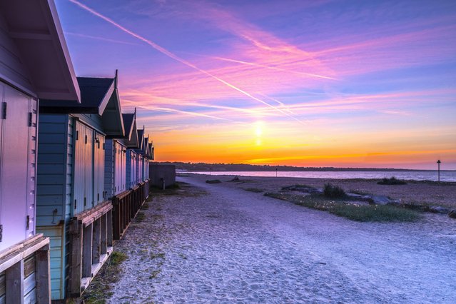 The sun rises over Mudeford beach in Dorset, a county in southwest England on May 8, 2022. (Photo by South West News Service)