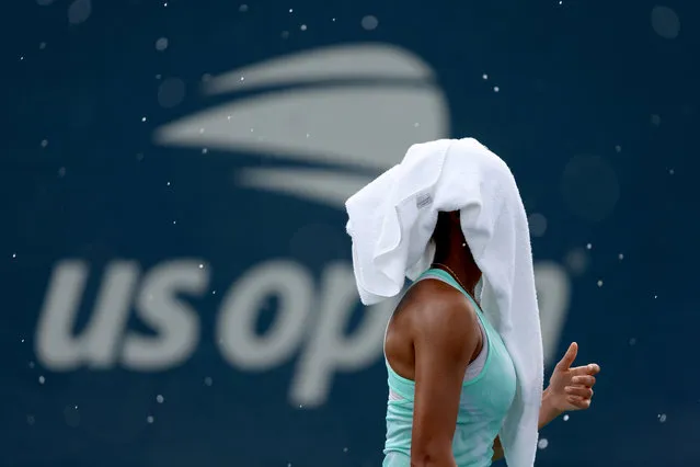 Ranah Akua Stoiber of Great Britain covers her head from rain against Kayla Cross of Canada during their Girl's Singles First Round match on Day Eight of the 2022 US Open at USTA Billie Jean King National Tennis Center on September 05, 2022 in the Flushing neighborhood of the Queens borough of New York City. (Photo by Julian Finney/Getty Images)