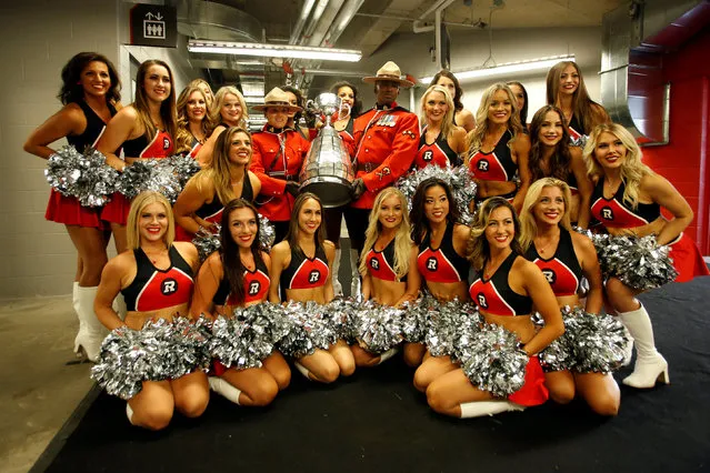 Royal Canadian Mounted Police officers hold the Grey Cup while posing with Ottawa Redblacks cheerleaders following a ceremony announcing Ottawa will host the 2017 Grey Cup championship football game in Ottawa, Ontario, Canada, July 31, 2016. (Photo by Chris Wattie/Reuters)