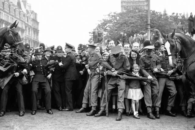 A young admirer tries her hardest to break away past a soldiers rifle, and reach the Royal Coach, as the King and Queen drove towards the House of Lords for the opening of Parliament in London on August 15, 1945. (Photo by AP Photo/File)