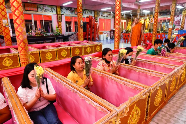 Thai people pray inside coffins as a Buddhist monk performs a rite during the New Year's resurrection ceremony at Wat Takien temple in Nonthaburi province, on the outskirts of Bangkok, Thailand, 01 January 2025. The resurrection ceremony rituals are performed at a Buddhist temple where Thai devotees lie in coffins symbolizing the concepts of death and rebirth in hopes of ushering in a new year filled with luck and the fulfillment of their wishes. (Photo by Rungroj Yongrit/EPA/EFE)