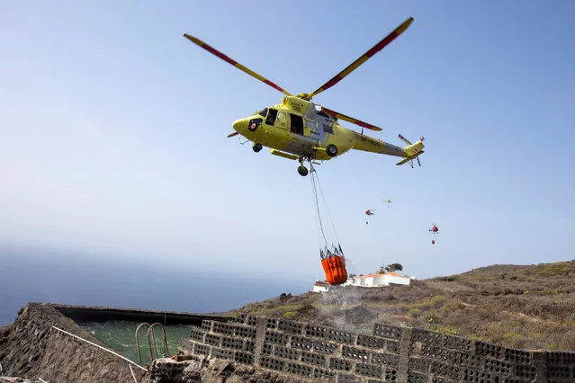 A helicopter works to extinguish a forest fire in Las Manchas on the southwestern part of La Palma island, Spain, August 6, 2016. (Photo by Borja Suarez/Reuters)