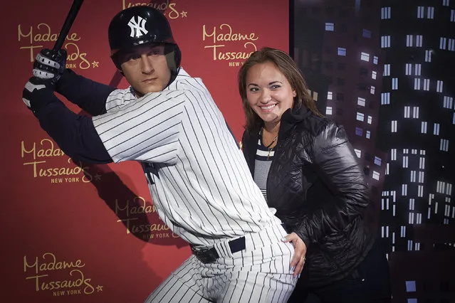 A woman poses for photos with a wax statue of New York Yankees' Derek Jeter at Madame Tussauds museum in the Manhattan borough of New York September 25, 2014. (Photo by Carlo Allegri/Reuters)