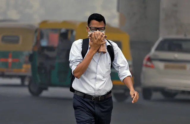 A man covers his face as he walks to work, in Delhi, India, November 7, 2017. (Photo by Saumya Khandelwal/Reuters)