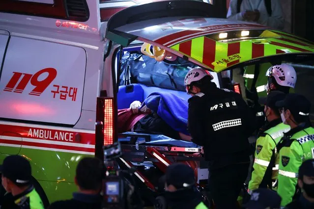 A person receives medical help at the scene where dozens of people were injured in a stampede during a Halloween festival in Seoul, South Korea, October 29, 2022. (Photo by Kim Hong-ji/Reuters)
