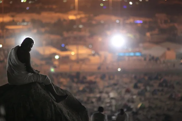 A Muslim pilgrim prays on a rocky hill called the Mountain of Mercy, on the Plain of Arafat, near the holy city of Mecca, Saudi Arabia, Wednesday, September 23, 2015 during the hajj pilgrimage. (Photo by Mosa'ab Elshamy/AP Photo)