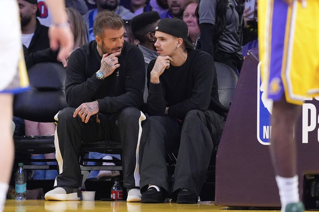 Former soccer player David Beckham, left, sits with his son Romeo as they watch during the second half of an NBA basketball game between the Los Angeles Lakers and the Golden State Warriors Thursday, April 3, 2025, in Los Angeles. (Photo by Mark J. Terrill/AP Photo)