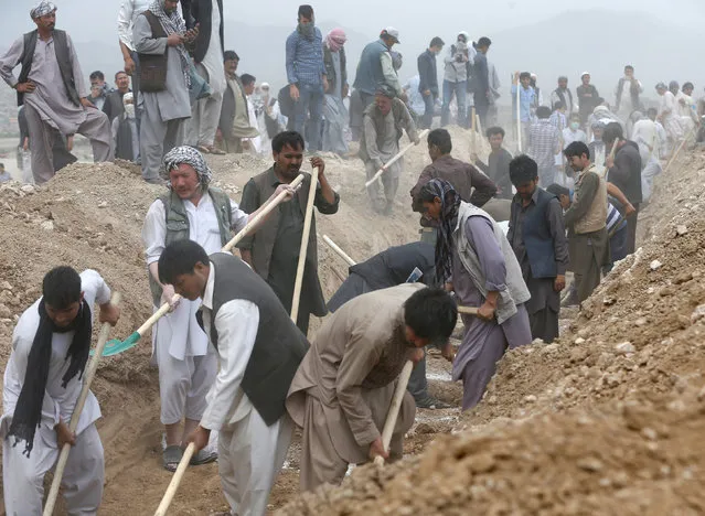 People dig graves for the victims of yesterday's suicide attack in Kabul, Afghanistan July 24, 2016. (Photo by Omar Sobhani/Reuters)