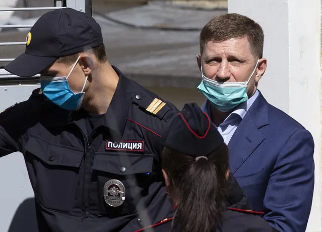 A governor of the Khabarovsk region along the border with China, Sergei Furgal, right, is escorted from a court room in Moscow, Russia, Friday, July 10, 2020. A provincial governor in Russia's far east has been arrested on charges of involvement in multiple murders and was flown to Moscow. The court ordered Frugal to be jailed for two months as the investigation continues. (Photo by Alexander Zemlianichenko/AP Photo)