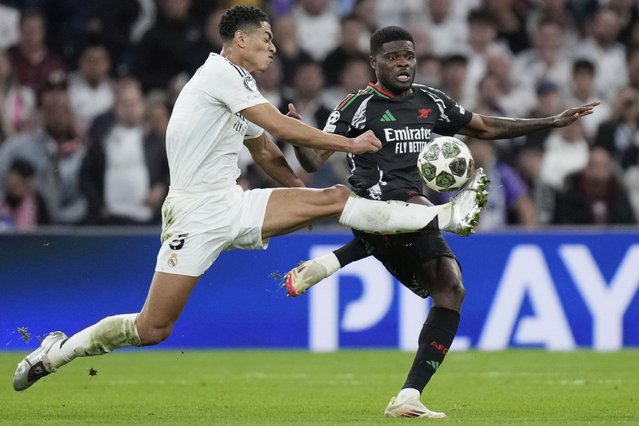 Real Madrid's Jude Bellingham, left, duels for the ball with Arsenal's Thomas Partey during the Champions League quarterfinals second leg soccer match between Real Madrid and Arsenal at the Santiago Bernabeu stadium in Madrid, Wednesday, April 16, 2025. (Photo by Bernat Armangue/AP Photo)