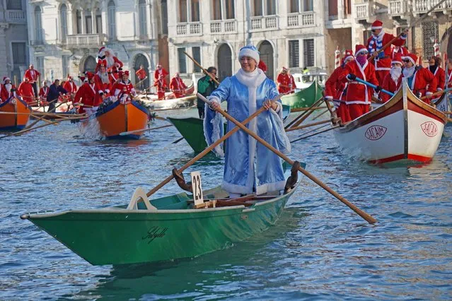 People wearing Santa Claus costumes row on Canal Grande in Venice, Italy, Sunday, December 17 2017. Almost a hundred traditional rowing boats, of various kinds and sizes, for about two hundred rowers, gave life to the traditional water procession of the Santa Claus, parading along the Grand Canal. (Photo by Andrea Merola/ANSA via AP Photo)