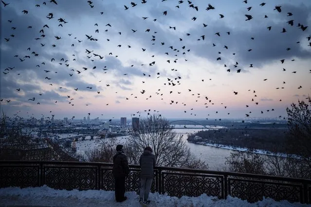 A flock of crows flies over downtown Kyiv on December 6, 2022, amid the Russian invasion of Ukraine. With temperatures dipping below zero, repeated Russian attacks have left Ukraine's energy grid teetering on the brink of collapse and have disrupted power and water supplies to millions over recent weeks. (Photo by Dimitar Dilkoff/AFP Photo)