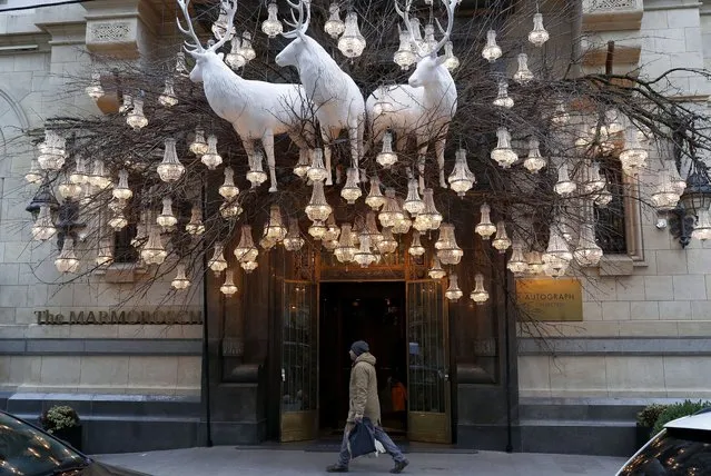 A man passes the entrance of a boutique hotel whose facade is decorated for Christmas in downtown Bucharest, Romania, 14 December 2022. Romania, an Orthodox-Christian country, celebrates Christmas on 25 December. (Photo by Robert Ghement/EPA/EFE)