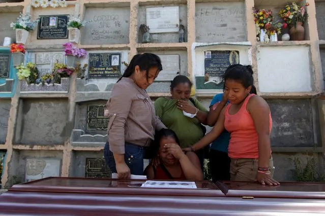 Relatives of a mudslide victim mourn over his coffin at a cemetery in Santa Catarina Pinula, on the outskirts of Guatemala City, October 6, 2015. (Photo by Jose Cabezas/Reuters)