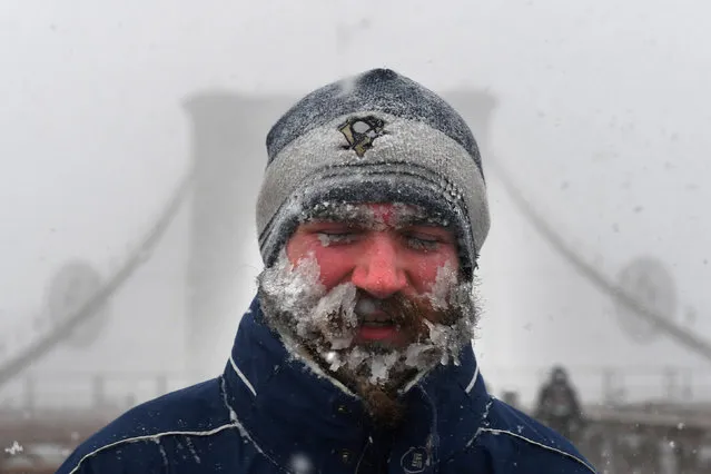 A pedestrian walks through blinding snow across the Brooklyn Bridge during Storm Grayson in New York City, U.S., January 4, 2018. (Photo by Darren Ornitz/Reuters)