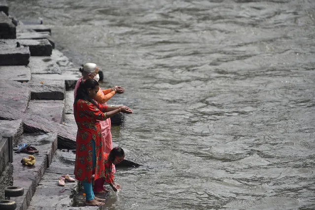 Nepalese devotees offer ritual prayer in the Bank of Bagmati River during Teej festival celebrations at Kathmandu, Nepal on Friday, August 21, 2020. The Teej festival is celebrated by Hindu women in Nepal as well as in some parts of India. During the three-day long festival, women observe a day-long fast and pray for the long life of their husbands as well as for a happy family. Those who are unmarried pray for a good husband and a long life. Due to prohibitory order lockdown in Kathmandu valley for a week-long, as rapid increase in the number of COVID-19 cases. (Photo by Narayan Maharjan/NurPhoto via Getty Images)