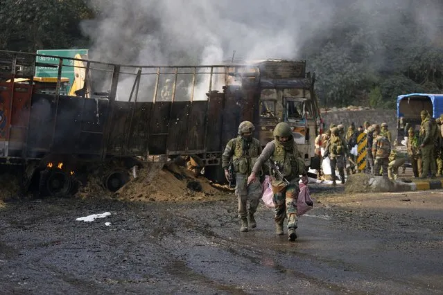 Indian army soldiers carry belongings of suspected rebels after a gunfight at Nagrota, on the Jammu-Srinagar highway, Indian-controlled Kashmir, Wednesday, December 28, 2022. A top police officer, Mukesh Singh, said troops intercepted a truck in the outskirts of Jammu city early Wednesday following its “unusual movement” on a highway. As the troops began searching the truck, gunfire came from inside it, to which the troops retaliated, leading to a gunfight killing four suspected militants, Singh told reporters. (Photo by Channi Anand/AP Photo)