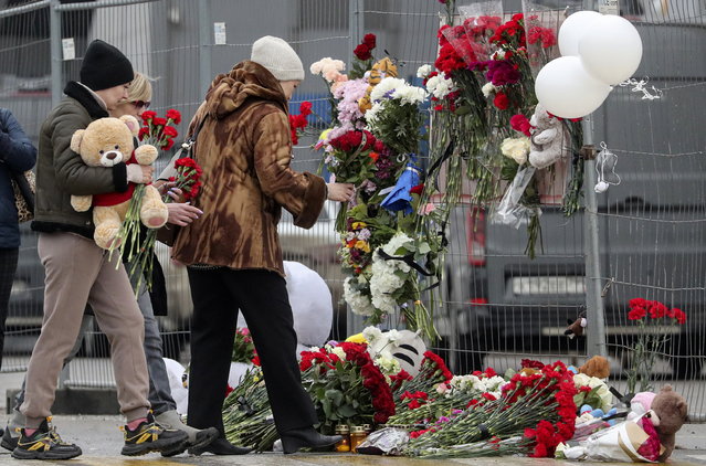 People mourn and bring flowers to the Crocus City Hall concert venue following a terrorist attack in Krasnogorsk, outside Moscow, Russia, 23 March 2024. On 22 March evening, a group of up to five gunmen attacked the Crocus City Hall in the Moscow region, Russian emergency services said. At least 115 people were killed and more than 100 others were hospitalized, the Investigative Committee confirmed. The head of the Russian FSB, Alexander Bortnikov, reported to Russian President Vladimir Putin on 23 March on the arrest of 11 people, including all four terrorists directly involved in the terrorist attack. (Photo by Maxim Shipenkov/EPA)