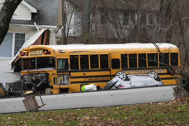 A school bus involved in an accident is seen in New Hempstead, N.Y., Thursday, December 1, 2022. Multiple injuries were reported Thursday when a school bus crashed into a house and another vehicle in a suburb north of New York City. (Photo by Seth Wenig/AP Photo)