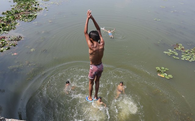 Boys jump into the water of Dal Lake to beat the heat on a hot day in the outskirts of Srinagar, the summer capital of Indian Kashmir, 20 June 2025. Kashmir witnessed an unprecedented heatwave. On 19 June 2025, Srinagar recorded the highest-ever June temperatures in 20 years. (Photo by Farooq Khan/EPA/EFE)