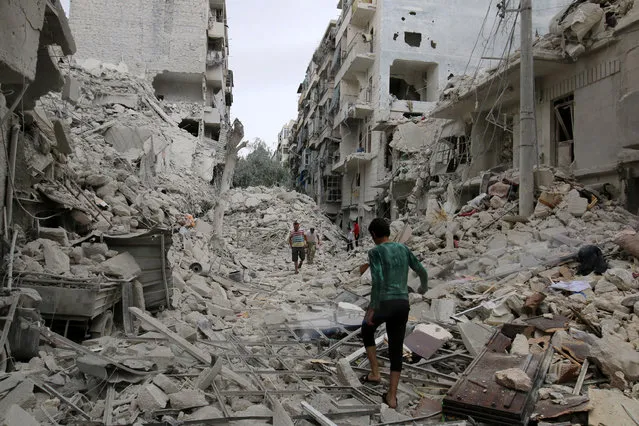 People inspect a damaged site after airstrikes on the rebel held Tariq al-Bab neighbourhood of Aleppo, Syria September 23, 2016. (Photo by Abdalrhman Ismail/Reuters)