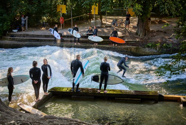 Surfers ride waves on the Eisbach in the English Garden in Munich, Germany on July 12, 2025. (Photo by David Levene/The Guardian)