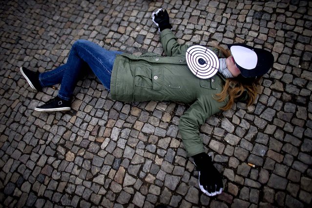 A member of the human rights organization Amnesty International lays on the ground during a demonstration marking International Women's Day in Berlin. (Photo by Markus Schreiber/Associated Press)
