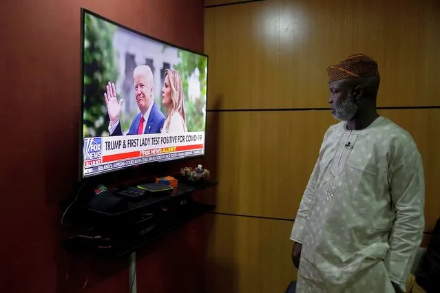 Accountant Abiodun Ayinde watches as the news announces U.S President Donald Trump and First Lady Melania Trump have tested positive for coronavirus, at his office in Lagos Friday, October 2, 2020. Global markets dropped after President Trump said that he and the first lady had tested positive for the coronavirus. (Photo by Sunday Alamba/AP Photo)