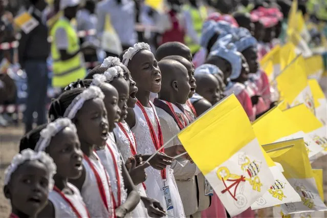 Young girls sing and wave Vatican flags as Pope Francis arrives at the St. Theresa Cathedral in Juba, South Sudan, Saturday, February 4, 2023. (Photo by Ben Curtis/AP Photo)