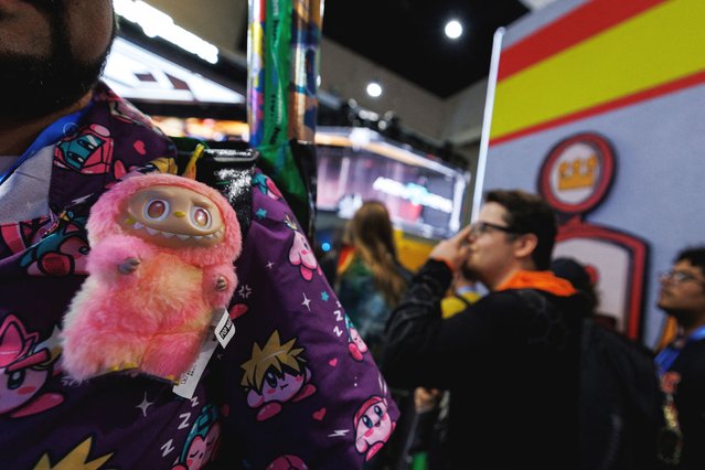 An attendee wears a Labubu at the Pop Mart booth on the convention floor during the opening day of Comic-Con International in San Diego, California, U.S. July 24, 2025. (Photo by Mike Blake/Reuters)