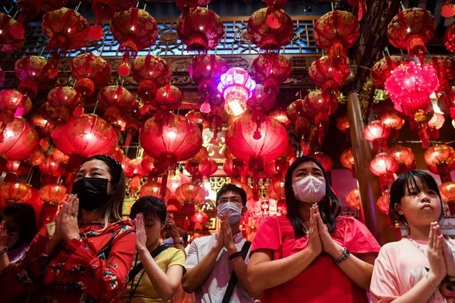 People make offerings on Lunar New Year's Eve at a temple in China Town in Bangkok, Thailand on January 21, 2023. (Photo by Chalinee Thirasupa/Reuters)