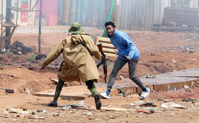 A riot police officer runs towards a protester during anti-government protests dubbed “Saba Saba People's March” anti-government protest in Nairobi, Kenya on July 7, 2025. (Photo by Monicah Mwangi/Reuters)