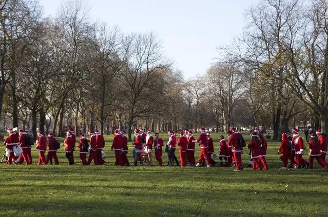 Participants in Santa costumes walk through Clapham Common during the annual SantaCon event in London December 6, 2014. (Photo by Neil Hall/Reuters)
