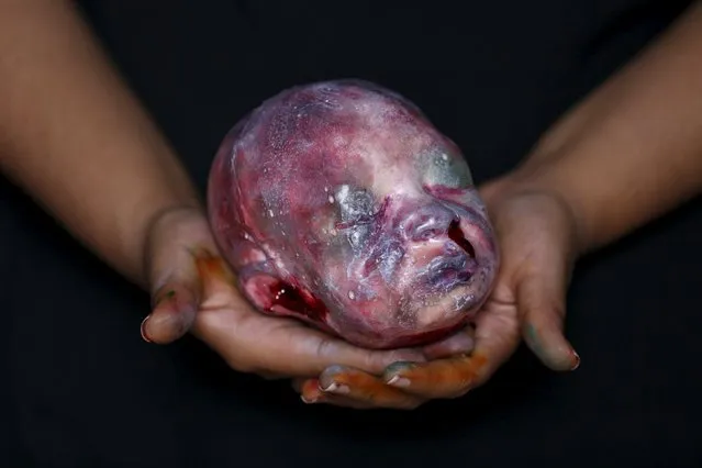 A bloody zombie baby head made of gummy candy and red jelly is pictured at the Zombie Gourmet homemade candy manufacturer on the outskirts of Mexico City October 30, 2015. (Photo by Carlos Jasso/Reuters)