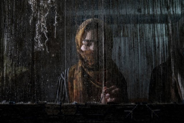 An Afghan woman weaves a carpet at a traditional carpet factory in Kabul, Afghanistan, Monday, March 6, 2023. After the Taliban came to power in Afghanistan, women have been deprived of many of their basic rights. (Photo by Ebrahim Noroozi/AP Photo)
