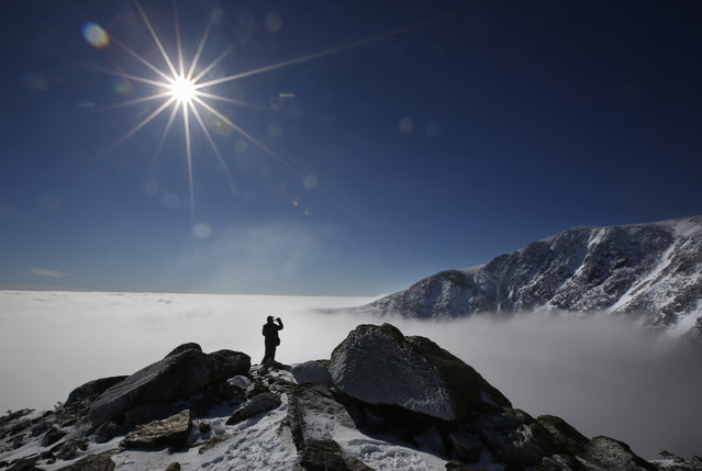 Guillaume Clermont of Montreal takes a water while climbing Mount Washington, Tuesday, March 6, 2018, near Pinkham Notch, N.H. A sea of clouds flow into Tuckerman Ravine below Clermont on an unusually mild day on the northeast's highest peak. A second nor'easter in as many weeks is expected to hit New England on Wednesday. (Photo by Robert F. Bukaty/AP Photo)