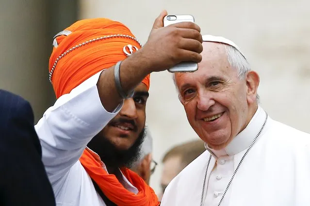 Pope Francis poses for a selfie with a member of the inter-religious community during the weekly audience in Saint Peter's Square at the Vatican October 28, 2015. (Photo by Stefano Rellandini/Reuters)