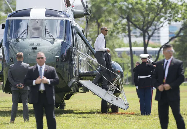 US President Barack Obama (C) disembarks from Marine One after transferring from his plane upon arrival in Manila on November 17, 2015 to attend the Asia-Pacific Economic Cooperation (APEC) Summit. Asia-Pacific leaders arrive in the Philippines on November 17 for a summit meant to foster trade unity but with terrorism and territorial rows in focus. (Photo by Saul Loeb/AFP Photo)