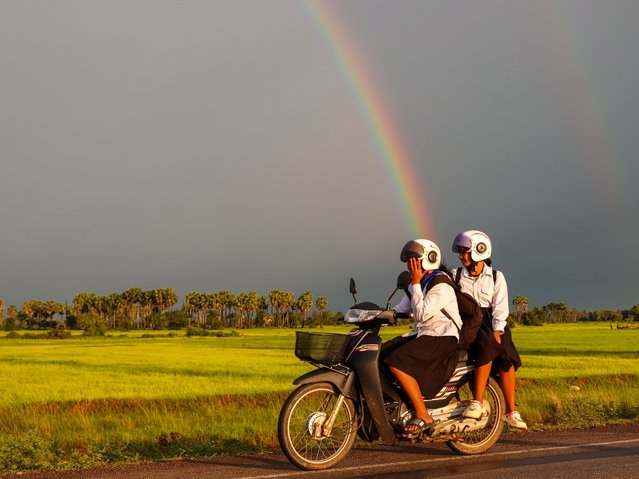 Cambodian motorcyclists drive near a double rainbow, following the conclusion of a ceasefire deal between Cambodia and Thailand, in Siem Reap, Cambodia, on July 29, 2025. (Photo by Daniel Ceng/Anadolu via Getty Images)